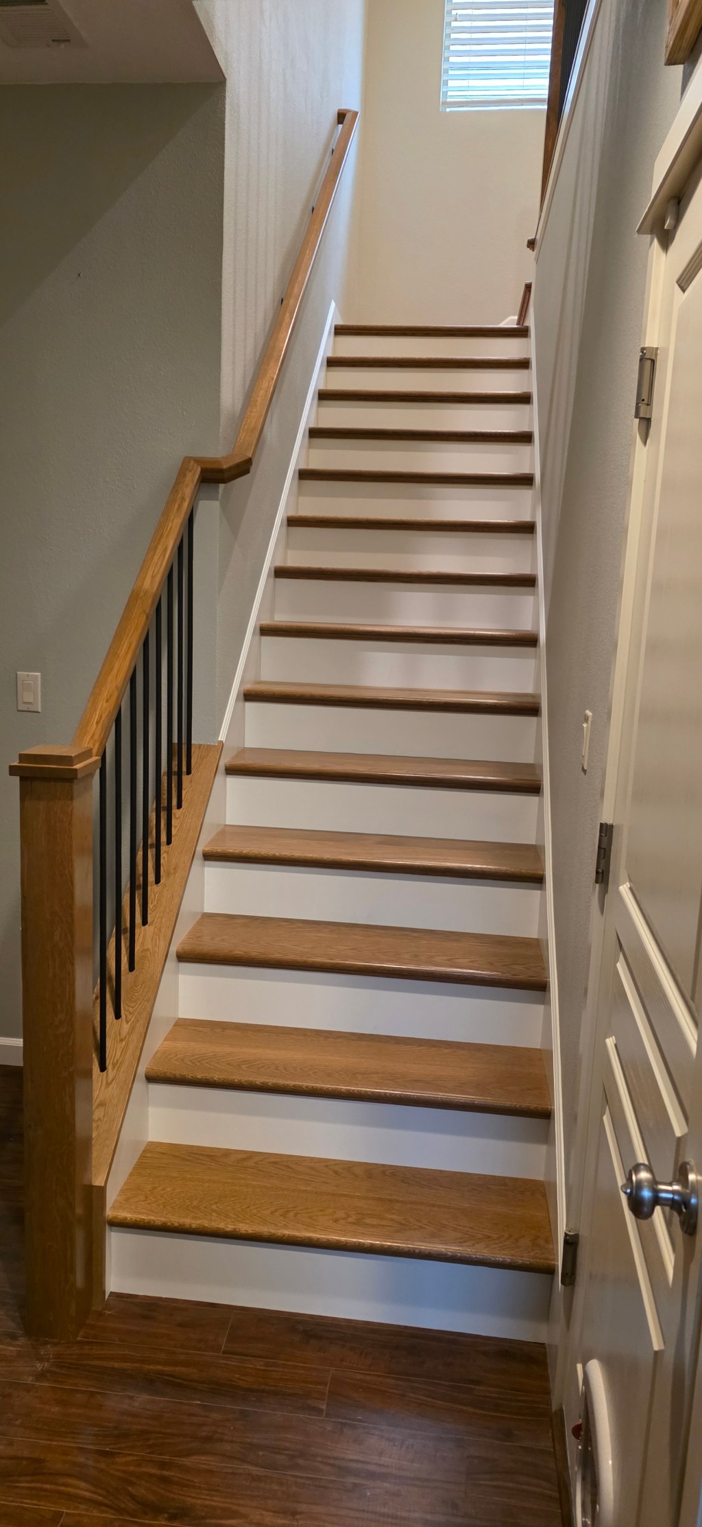 AFTER: Staircase with pony walls removed and stain color matched to new floors at the Hidden Glen home.