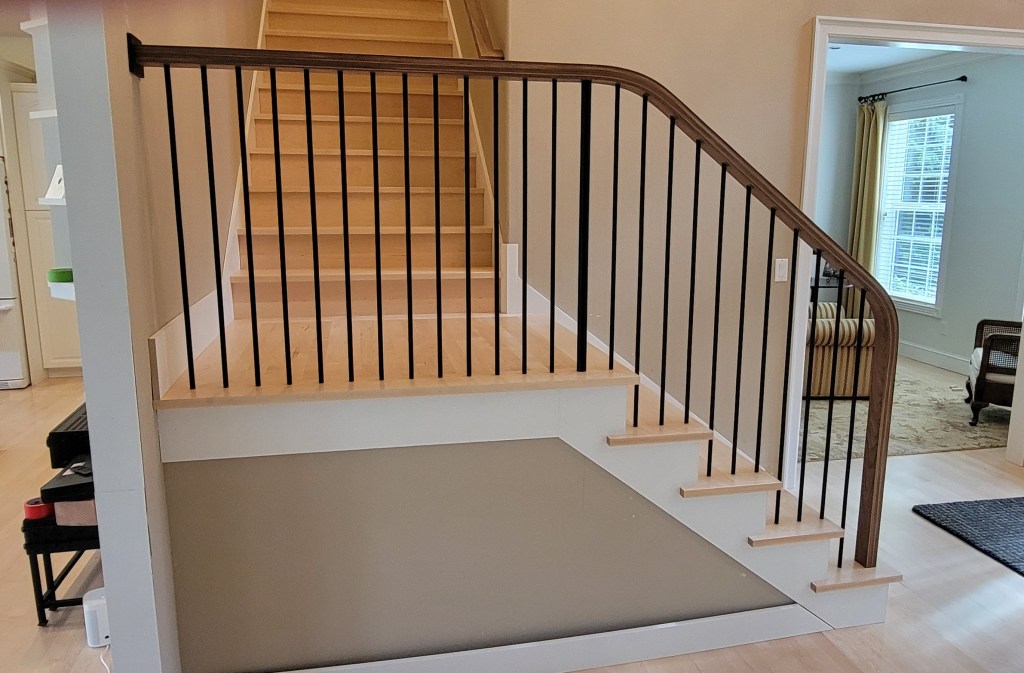 AFTER: We used the clients rail pattern as a template to laminate and bend Black Walnut
landing and stair railing in one section. We also corrected existing staircase and installed the clients
wood parts for the treads, risers and landing.