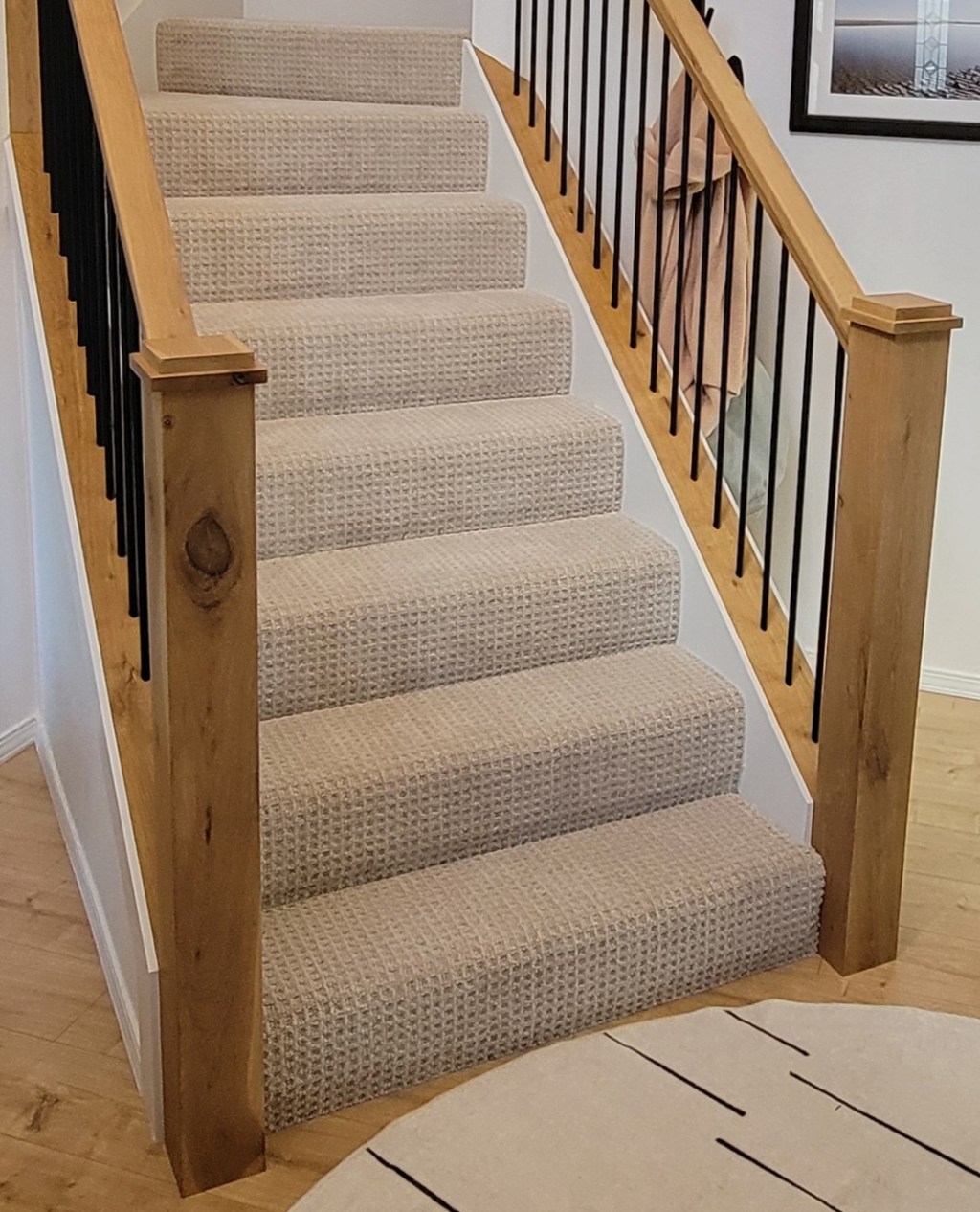 AFTER: Modernized staircase with new sub stair treads and clear coated Rustic White Oak caps, railings, and posts at the South Salmon Creek home.