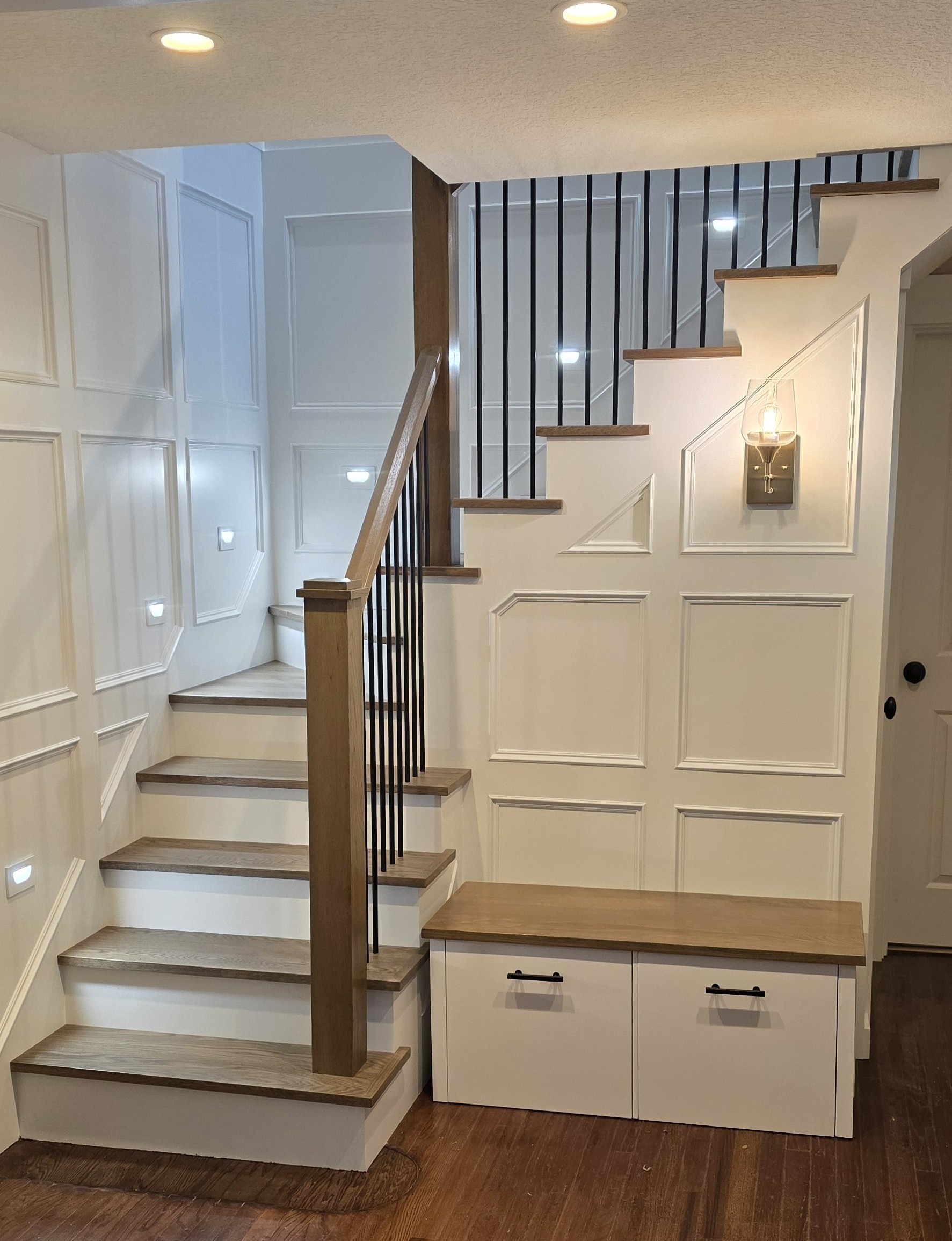 After falling down this staircase, the clients had enough. We completely rebuilt this staircase and gave it more head clearance on the lower portion, with wainscoting to change the overall look.