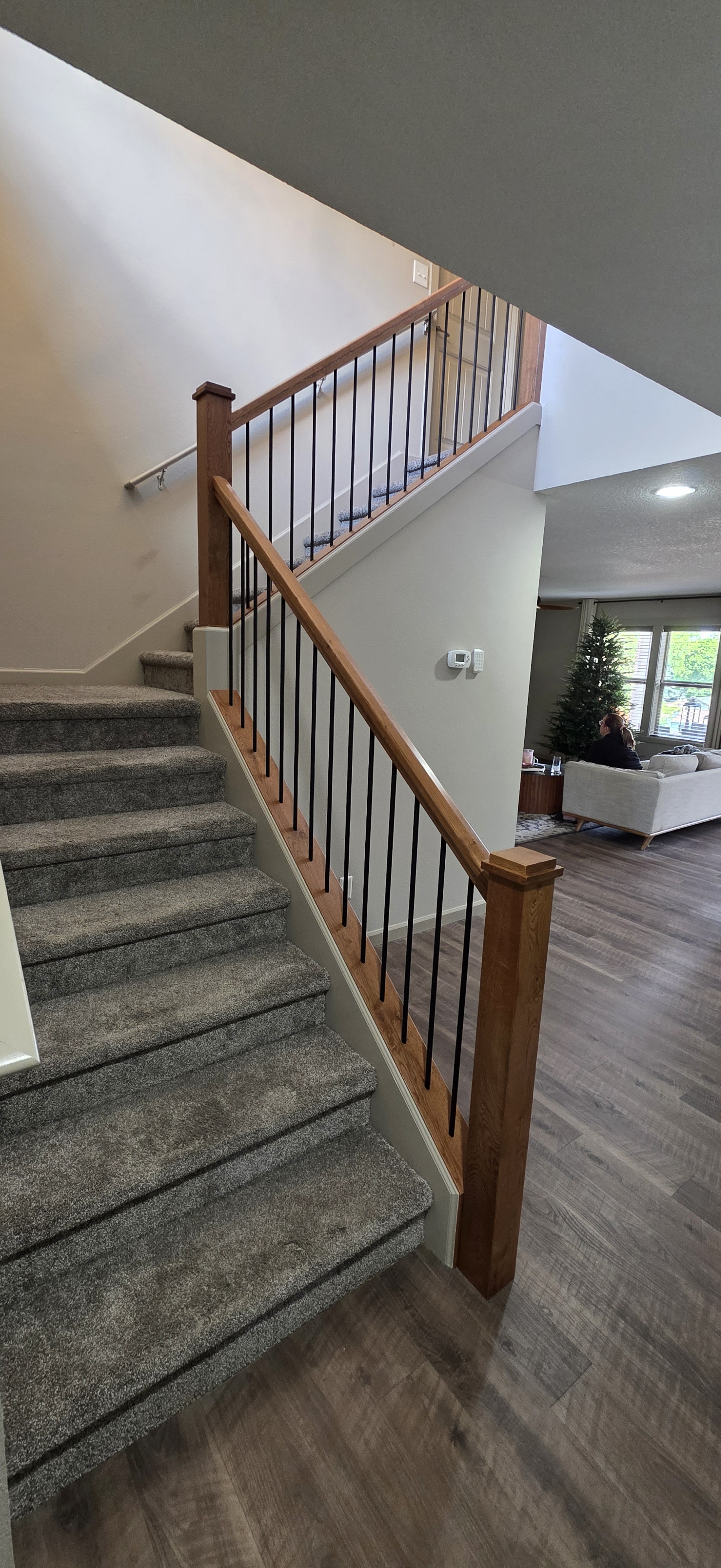 The staircase felt closed in. After removing the upper and lower pony walls we painted and installed skirt boards with Rustic White Oak caps, railings and posts.