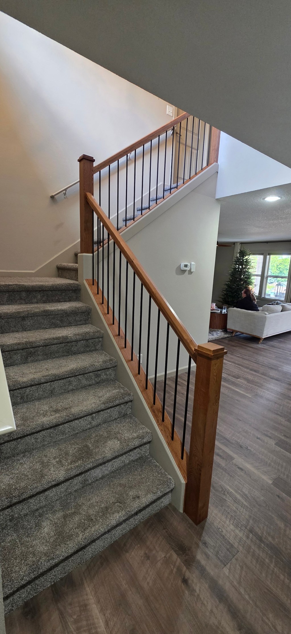 AFTER: Staircase with pony walls removed, painted skirt boards, and Rustic White Oak caps and railings at the St. Johns home.