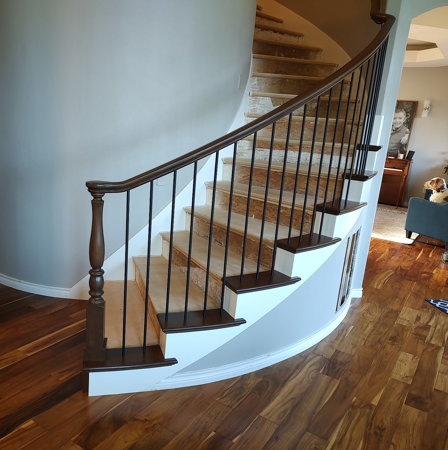 The existing staircase was out dated and not code passing. We removed all the railings, post, treads and risers then adjusted and leveled each tread and adding more backing to support the new treads. Our installers bent, installed and painted the inside and outside skirt boards on the staircase.